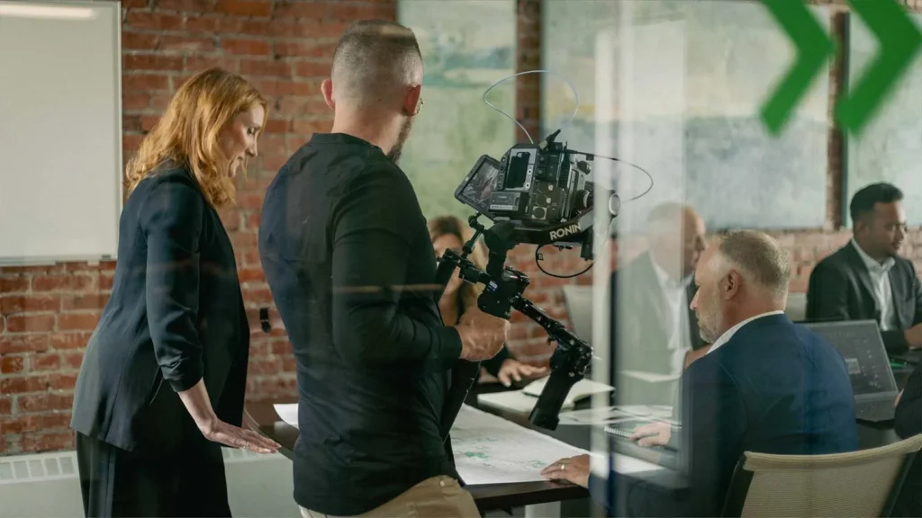 A director on set in Calgary frames a shot for a corporate video production, showcasing professional pre-production planning.